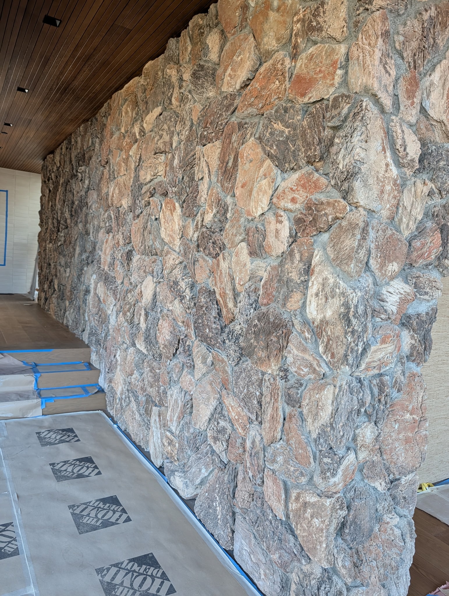 Baja Drift thin veneer — Malibu interior stone wall with wood ceiling
