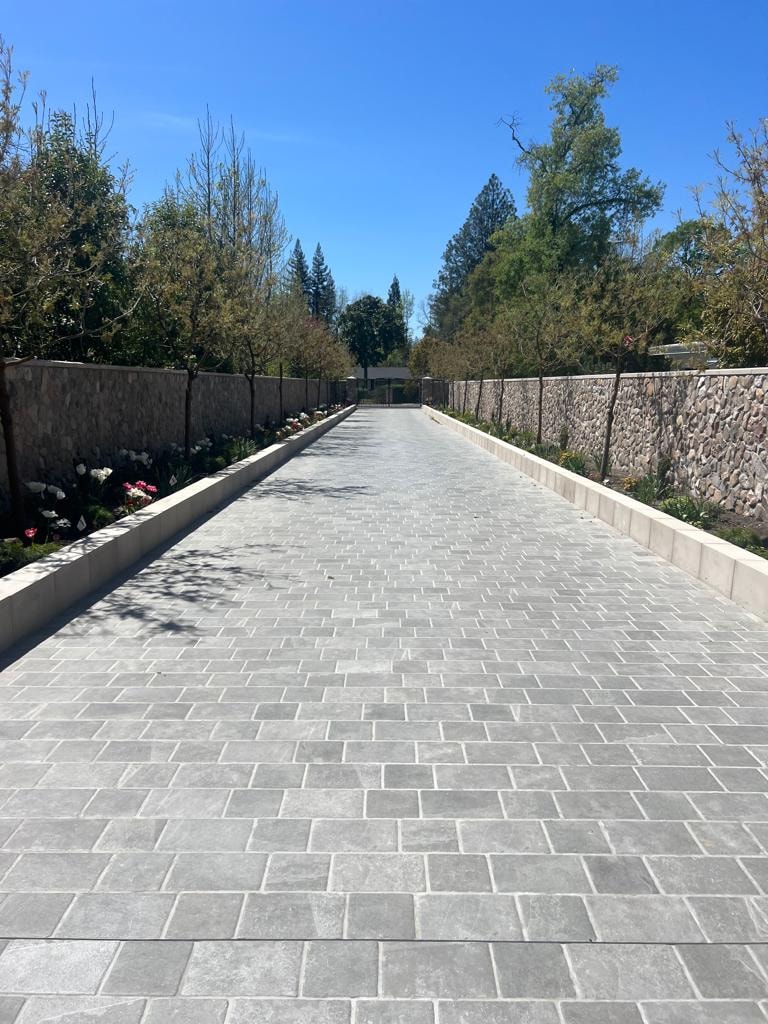 Mexican River Rock — stone walls lining a paved driveway